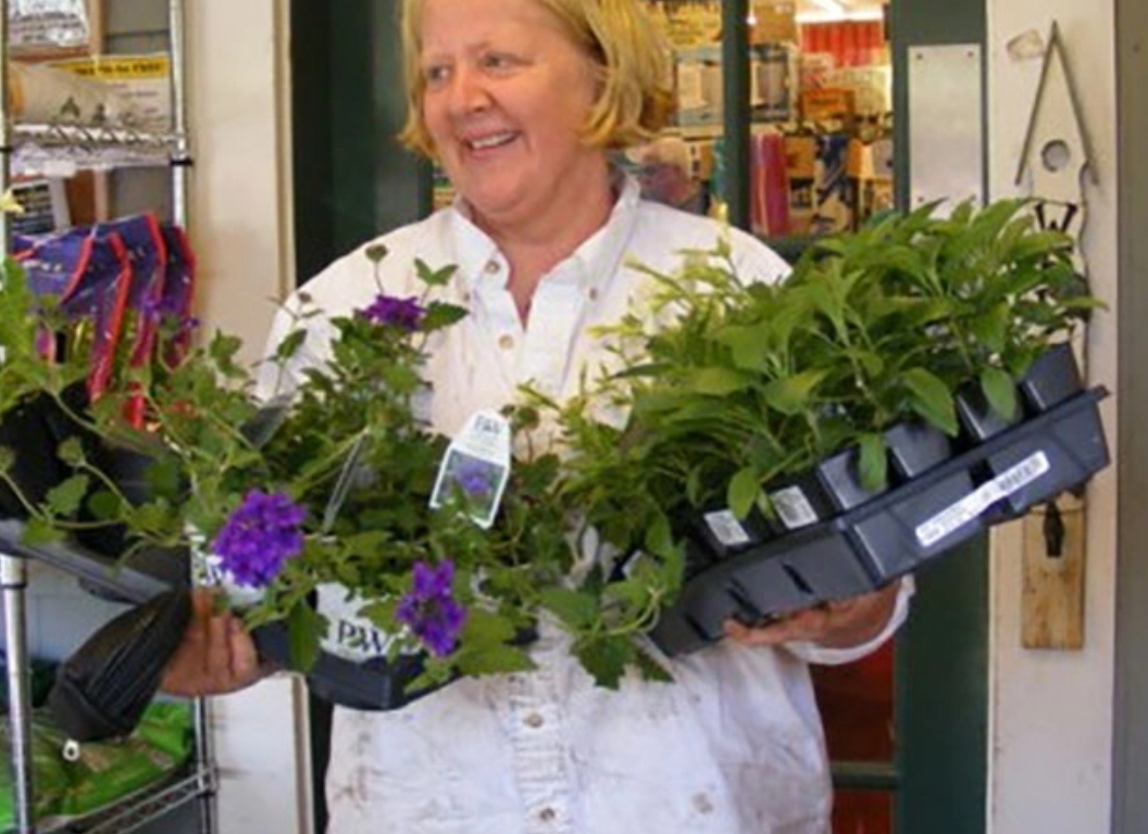 A woman with flowers in her hands works at a shop