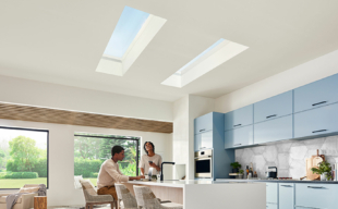 Two adults look up at their skylights in the kitchen ceiling