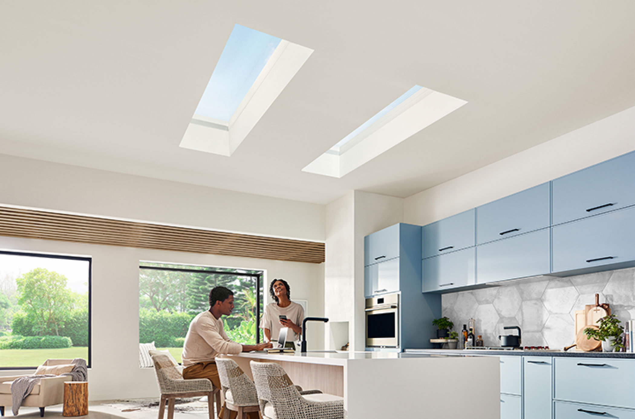 Two adults look up at their skylights in the kitchen ceiling