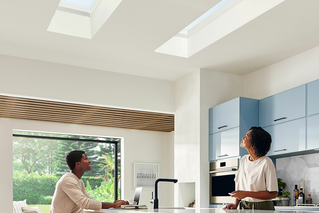 Two adults look up at their skylights in the kitchen ceiling