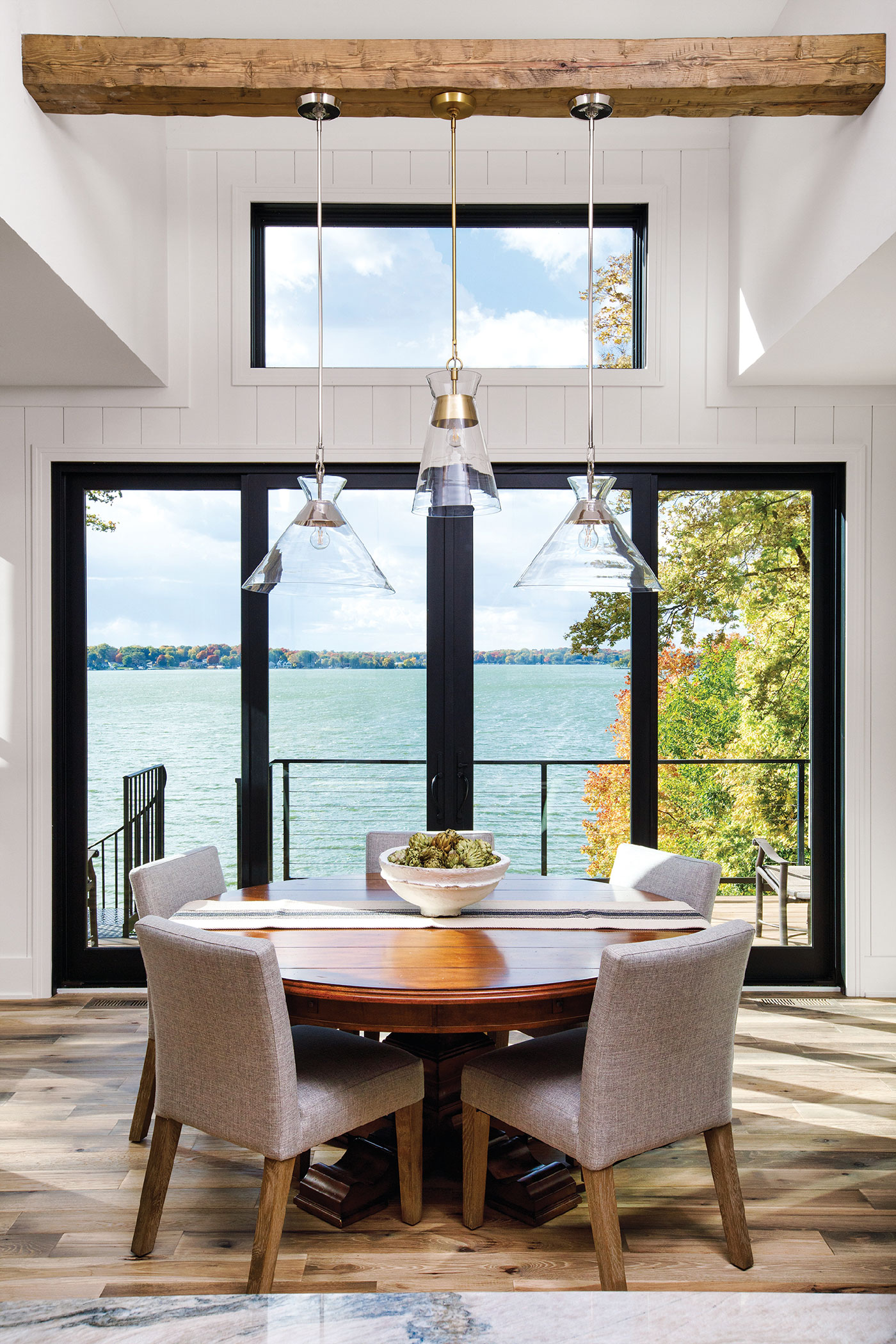 four black framed modern looking doors allow the ocean view to enter the comfortable dining room