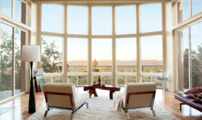 A curved wall of viewing windows with two chairs next to each other