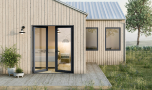 An ajar, full height glass door on the front of a simple, modern home.