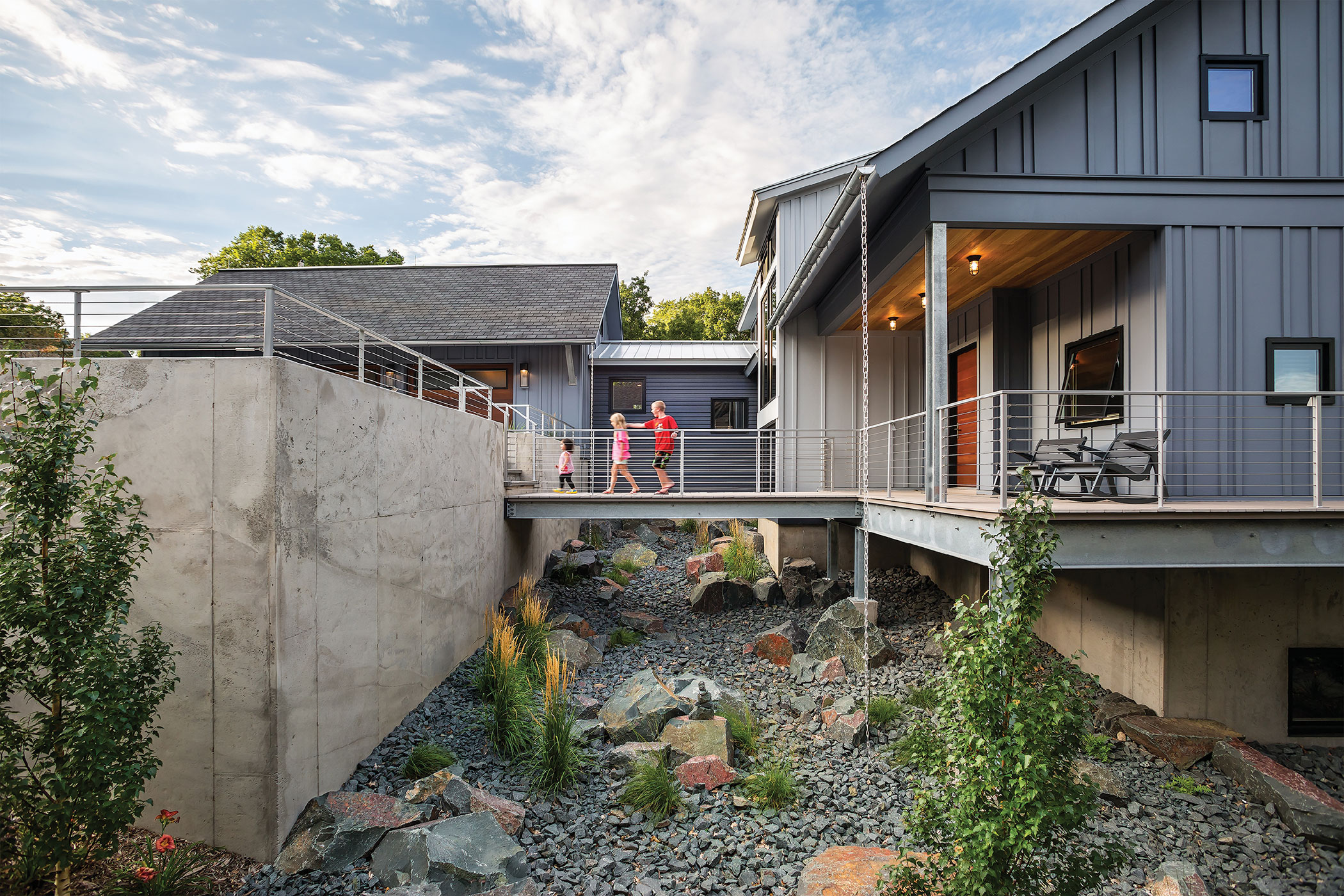 a cross walk connects the main house and the out building of a modern home.