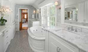 a bank of classic white wood windows run the length of a large bathroom wall