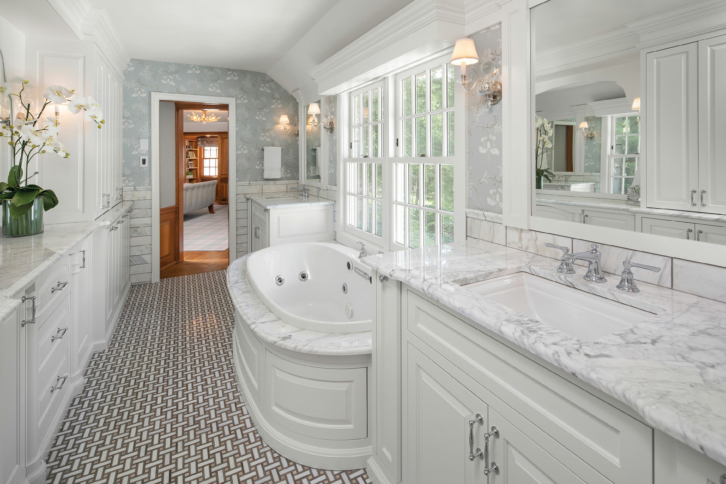 a bank of classic white wood windows run the length of a large bathroom wall