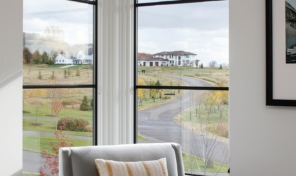 A sitting room with corner floor to ceiling windows