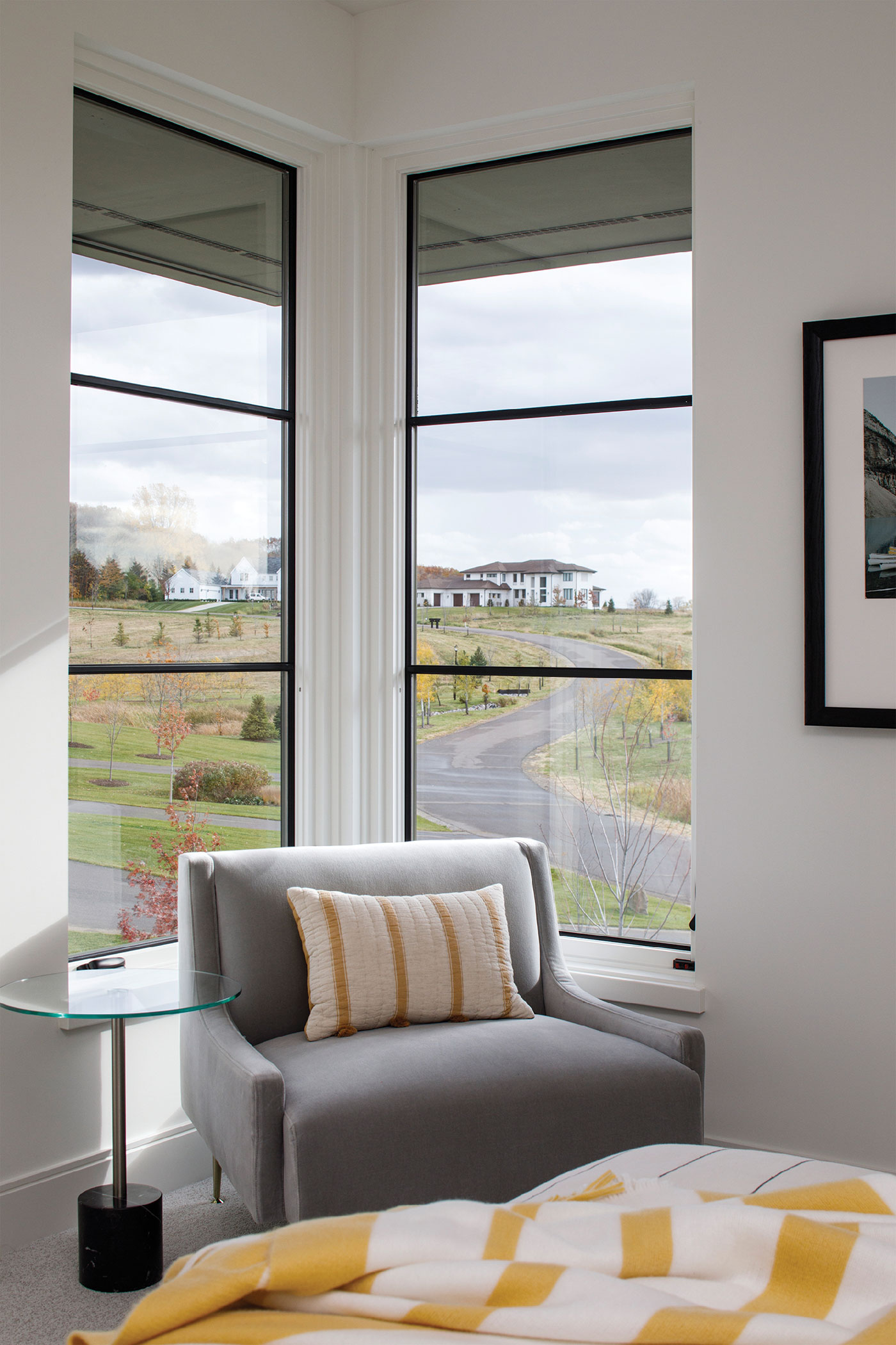 A sitting room with corner floor to ceiling windows